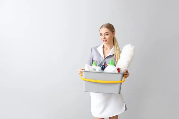 Beautiful Young Chambermaid Cleaning Supplies Light Background — Stock Photo, Image