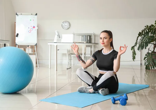 Young woman meditating in office