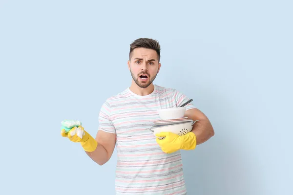 Unzufriedener Mann Mit Schmutzigem Geschirr Und Schwamm Auf Farbigem Hintergrund — Stockfoto