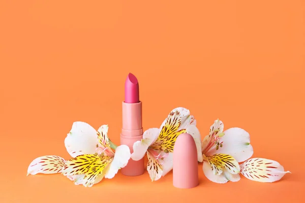 Lippenstift Und Blumen Auf Farbigem Hintergrund — Stockfoto