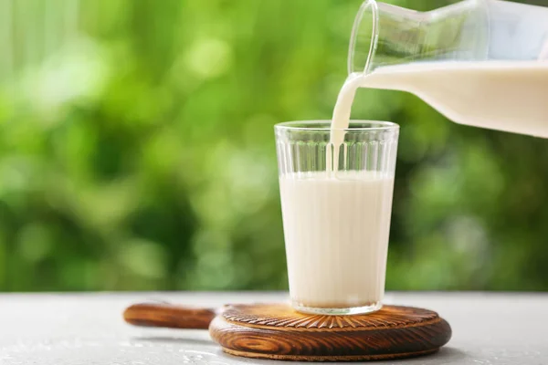 Verser Lait Dans Verre Sur Table Extérieur — Photo