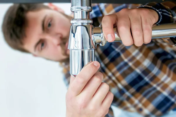 Lavabo borularını banyoya bağlayan tesisatçı.