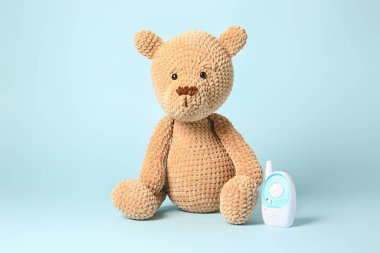 Arka planda bebek monitörü olan oyuncak ayı