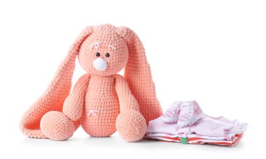 Beyaz arka planda bebek kıyafetleri olan sevimli tavşan.