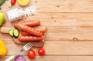 Lezzetli ızgara sosis ve sebzeler masada.