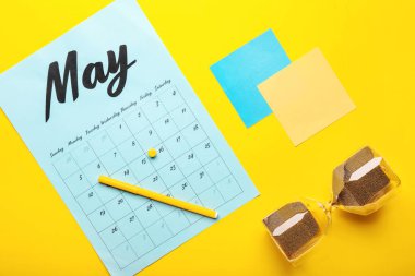 Kırtasiyeli takvim ve renk arkaplanlı kum saati. Son teslim tarihi kavramı