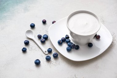 Lezzetli yoğurtlu kase ve beyaz arka planda böğürtlen