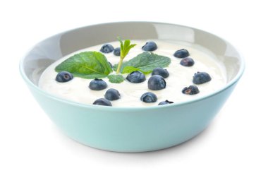 Lezzetli yoğurtlu kase ve beyaz arka planda böğürtlen