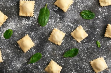 Koyu arkaplanda pişmemiş ravioli.