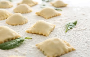 Beyaz arkaplanda pişmemiş ravioli