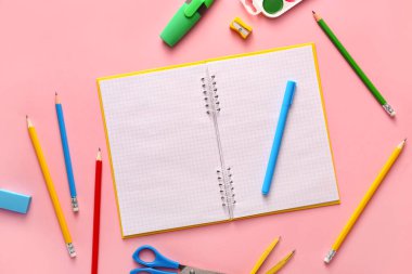 Renkli arka planda okul malzemelerinin olduğu defter