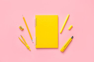 Renkli arka planda okul malzemelerinin olduğu defter