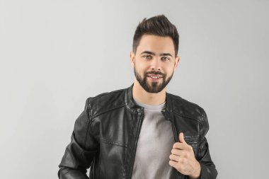 Açık arkaplanda sağlıklı saçlı yakışıklı bir adam.