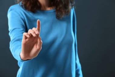 Koyu arkaplanda sanal ekran kullanan kadın