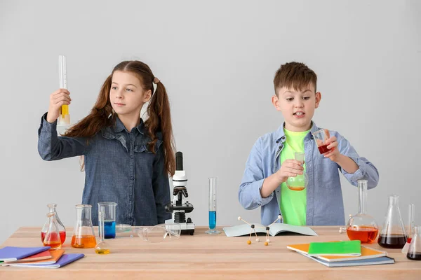 Crianças Pequenas Bonitos Estudando Química Mesa Contra Fundo Cinza — Fotografia de Stock