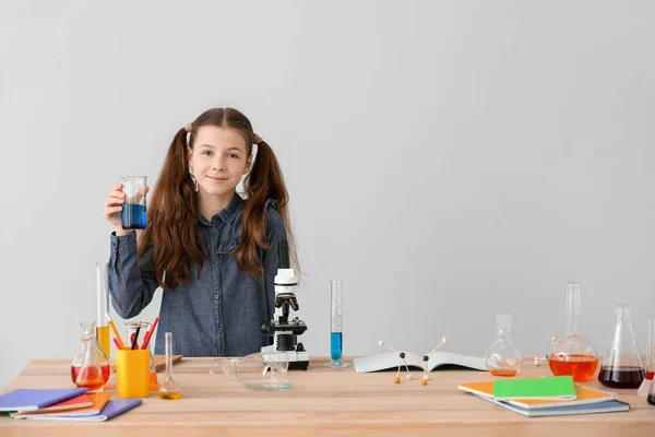 可愛いです女の子勉強化学でテーブルに対してグレー背景 — ストック写真