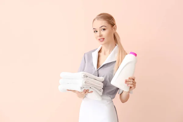 Piękna Młoda Pokojówka Ręcznikami Płynem Prania Tle Koloru — Zdjęcie stockowe