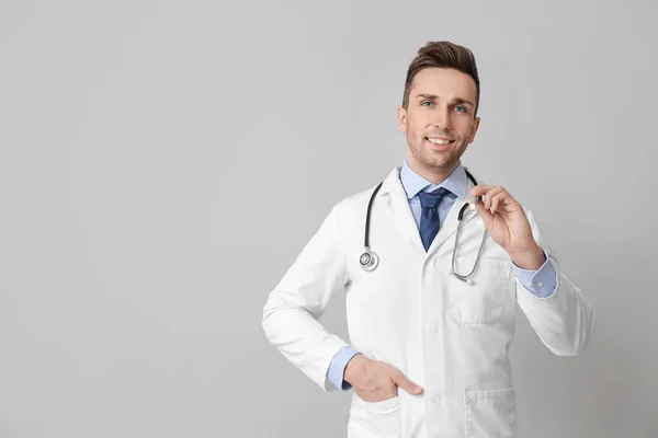 Medico Maschio Con Torcia Sfondo Grigio — Foto Stock