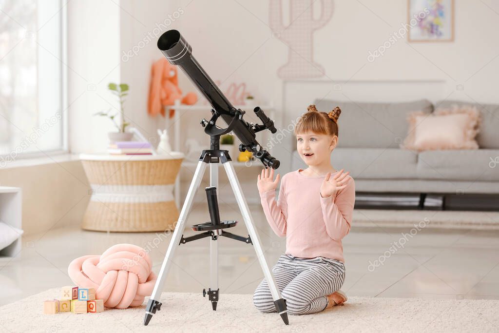 Cute little girl with telescope at home