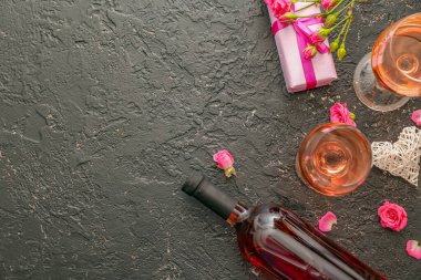 Kadehler ve bir şişe şarap. Arkaplanda hediye var.