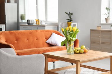 Masasında bir buket bahar çiçeği olan modern stüdyo dairesi.