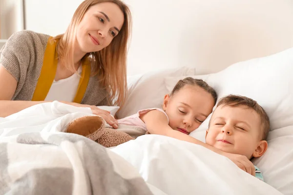 Nanny Lägger Söta Små Barn Sängen — Stockfoto