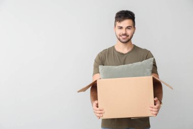 Arka planda paket olan genç bir adam.