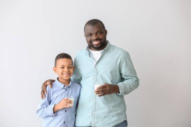 Afro-Amerikalı bir adam ve oğlu hafif arka planda sütle