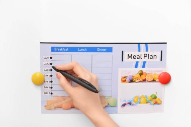 Beyaz arka planda yemek planı yapan kadın