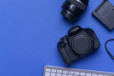 Renkli arkaplan üzerine modern fotoğrafçı ekipmanı ve bilgisayar klavyesi