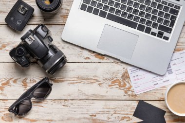 Beyaz ahşap arka planda dizüstü bilgisayarı olan modern fotoğraf makinesi