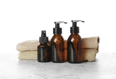 Masada beyaz arka planda şampuan ve havlular