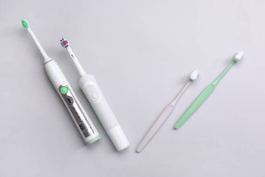 Gri arkaplanda yapıştırıcılı diş fırçaları