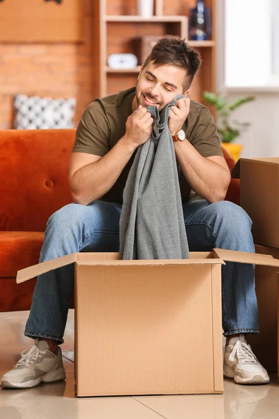 Young Man Unpacking Box New Clothes Home — Stock Photo, Image