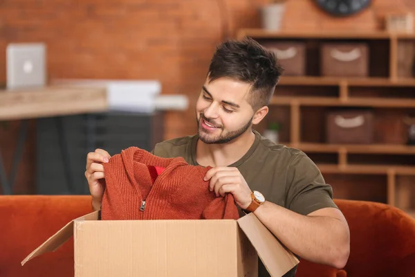 Young Man Unpacking Box New Clothes Home — Stock Photo, Image