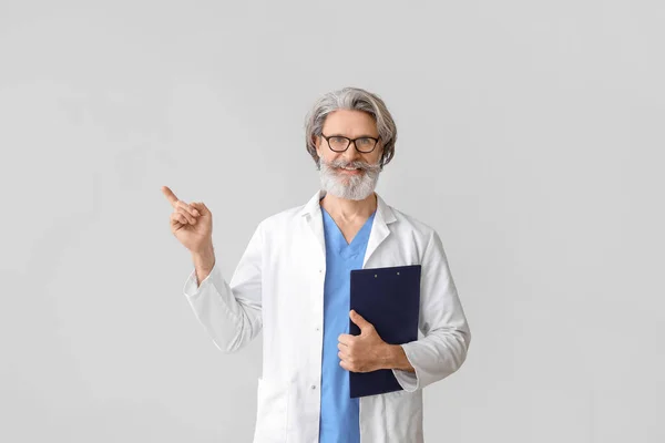 Retrato Médico Sênior Mostrando Algo Fundo Cinza — Fotografia de Stock