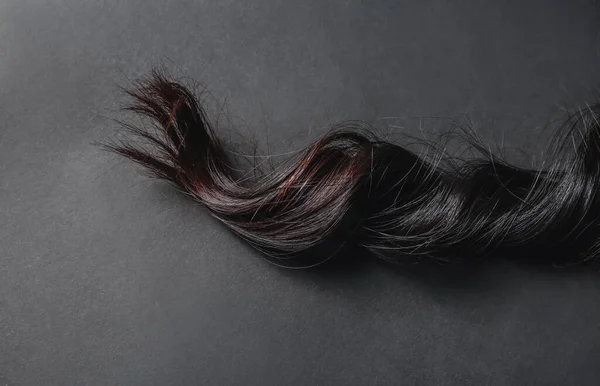 暗い背景に現在の女性の髪 — ストック写真