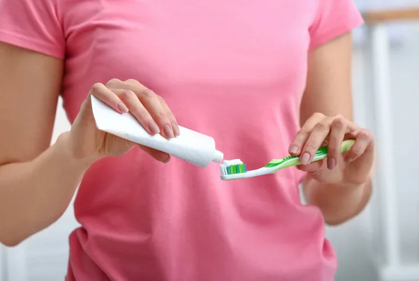 Woman with tooth brush and paste, closeup