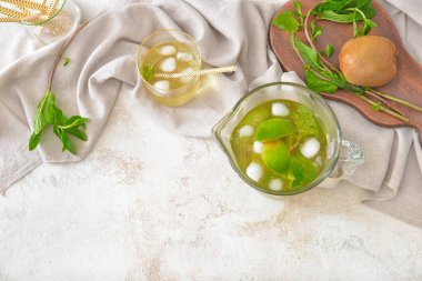 Beyaz arka planda bir sürahi ve bir bardak lezzetli soğuk çay.