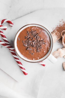 Işık masasında bir fincan sıcak çikolata ve şeker kamışı