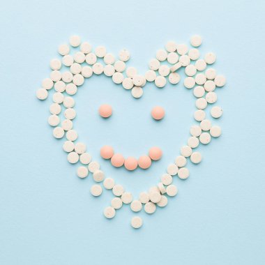 İnsan kalbi ve tebessümü renkli arkaplandaki haplardan yapılmıştır.