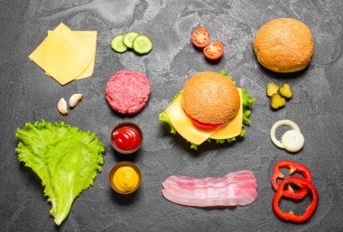 Koyu arkaplanda lezzetli burger için malzemeler