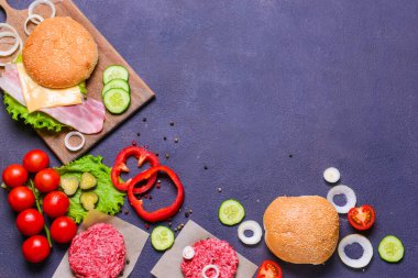 Koyu arkaplanda lezzetli burger için malzemeler