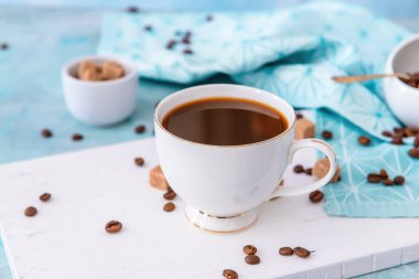 Masada bir fincan sıcak kahve ve fasulye.