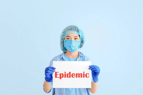 アジアの医師がカラー背景にテキストEpidemicと紙シートを保持 — ストック写真