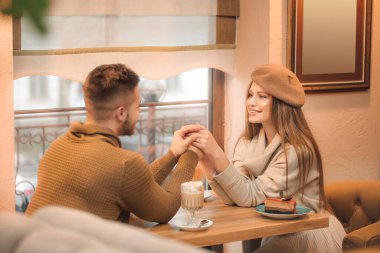 Kafede romantik bir randevuda olan mutlu genç çift