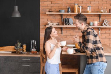 Genç çift mutfakta çay içiyor.