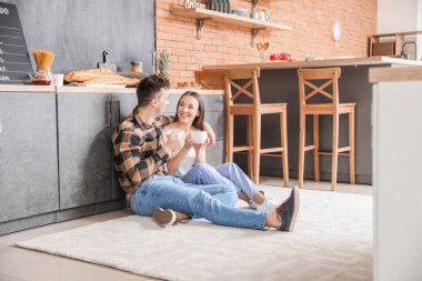 Genç çift mutfakta çay içiyor.