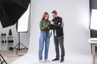 Profesyonel fotoğrafçı stüdyoda model resimleri gösteren