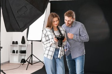 Profesyonel fotoğrafçı stüdyoda model resimleri gösteren